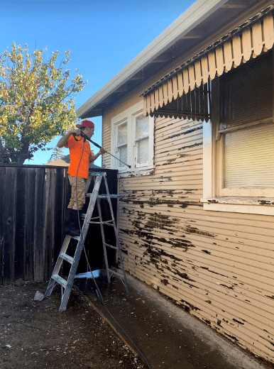 Exterior wood siding being scraped and prepared for repaint